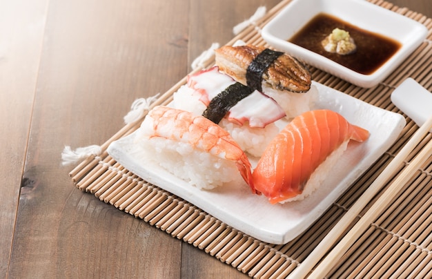 sushi z sosem i wasabi na płycie drewna