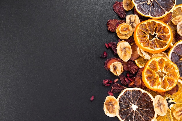 Zdjęcie suszone owoce na czarnym stole suszone pomarańcze suszone truskawki suszone mandarynki suszone figi