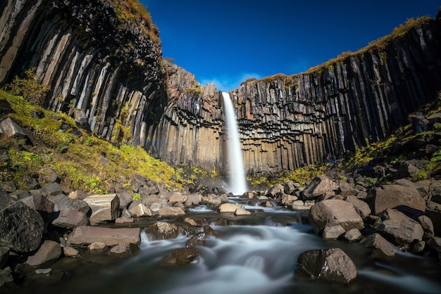 Svartifoss na Islandii. Dramatyczny wodospad otoczony sześciokątnymi kolumnami z czarnej lawy bazaltowej.