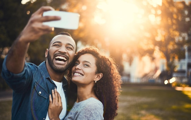 Świat dowie się o naszej prawdziwej miłości Ujęcie młodej pary robiącej razem selfie na świeżym powietrzu