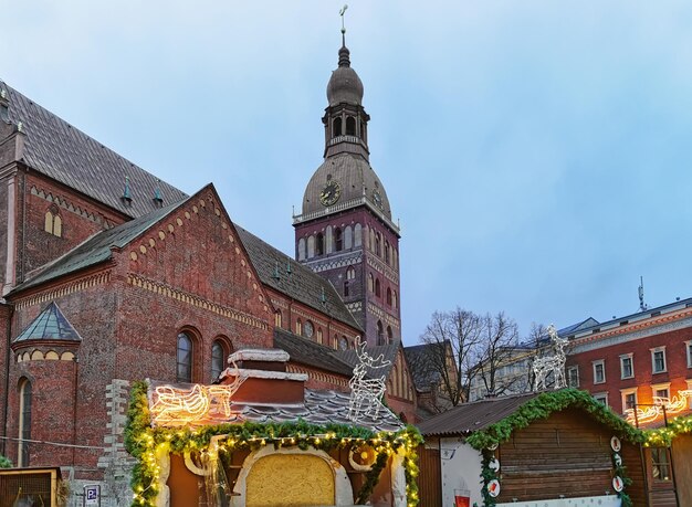 Świąteczna dekoracja straganów na jarmarku bożonarodzeniowym w pobliżu katedry kopułowej na placu kopułowym. W centrum starej Rygi na Łotwie.