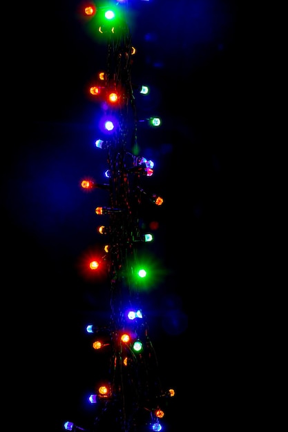 Świąteczna i noworoczna girlanda z jasnymi wielokolorowymi światłami na czarno na białym tle przestrzeni kopii