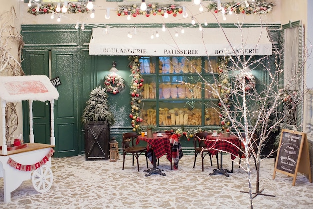 Zdjęcie Świąteczna kawiarnia na zewnątrz piekarni z dekoracjami świątecznymi i świeżym chlebem w szklanej gablocie