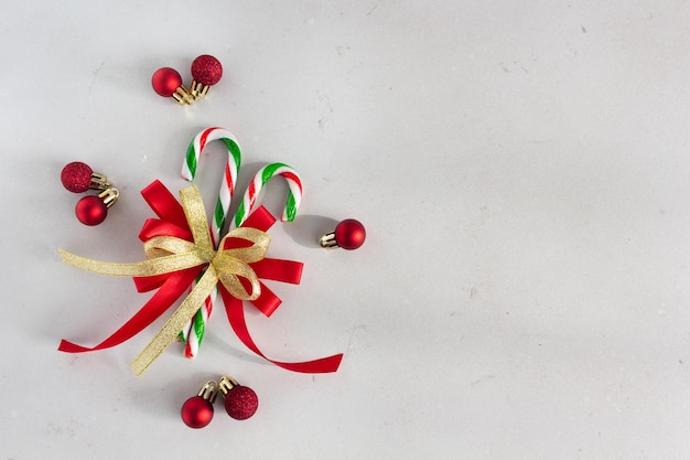 Zdjęcie Świąteczna kompozycja płaska z czerwonymi kulkami, cukierkami na jasnym tle