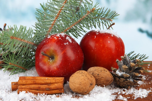 Świąteczna kompozycja z czerwonymi zimowymi jabłkami na jasnym tle