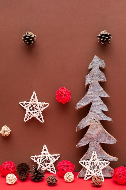 Świąteczna kompozycja z drewnianymi choinkami szyszki gwiazd na czerwonym biurku
