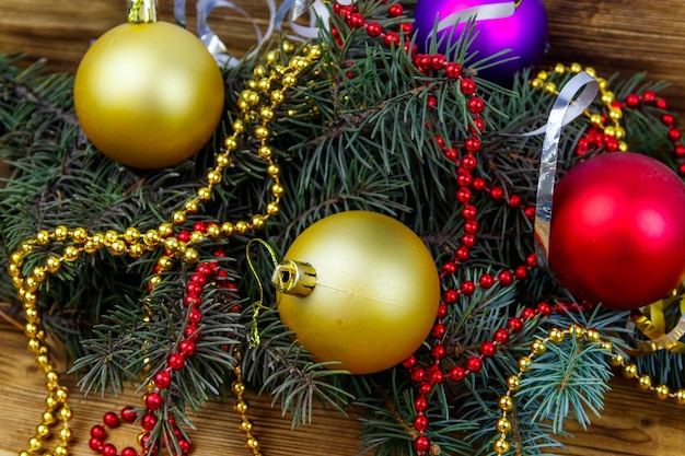 Zdjęcie Świąteczna kompozycja z gałęzi jodłowych i ozdób choinkowych na drewnianym stole. widok z góry