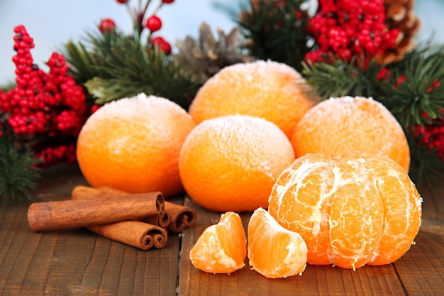 Zdjęcie Świąteczna kompozycja z oszronionymi dojrzałymi mandarynkami na drewnianym tle
