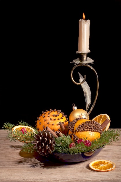 Zdjęcie Świąteczna kompozycja z pomarańczowymi pomandami i świecą na czarnym tle