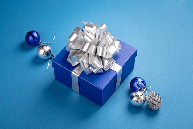 Świąteczna kompozycja z prezentem i dekoracjami w niebiesko-srebrnej kolorystyce