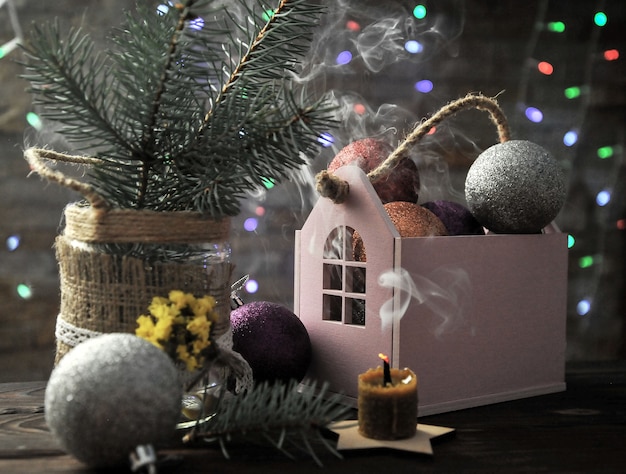 Świąteczna kompozycja ze świecą, domem i dekoracjami świątecznymi na stole
