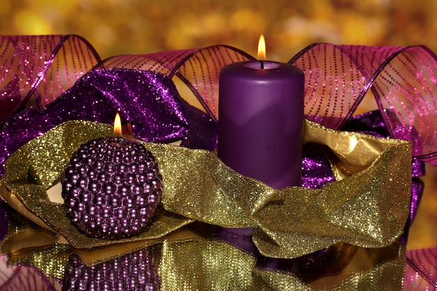 Świąteczna kompozycja ze świecami i dekoracjami w fioletowo-złotej kolorystyce