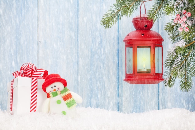 Świąteczna latarnia, pudełko i zabawka bałwan w śniegu. Zobacz z kopią miejsca