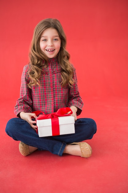 Świąteczna mała dziewczynka trzyma prezent