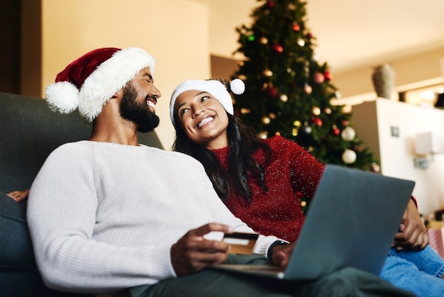 Świąteczna para i laptop na kanapie karta kredytowa lub szczęście razem e-commerce lub sezon świąteczny w salonie Świąteczna miłość lub kobieta z mężczyzną płatność bankowość internetowa lub szczęśliwy transakcja na kanapie