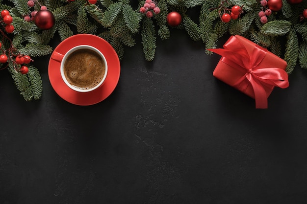 Świąteczna ramka z kawowym czerwonym prezentem nobilis oddziałuje czerwone kulki na kartkę z życzeniami