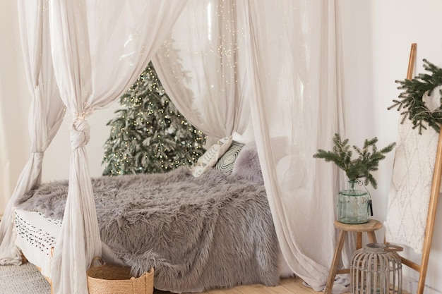 Świąteczna skandynawska sypialnia z białym baldachimem