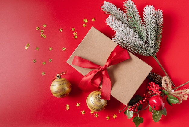 Świąteczne dekoracje świąteczne i noworoczne z pudełkiem, piłkami, szyszkami i zabawkami na czerwonym tle.