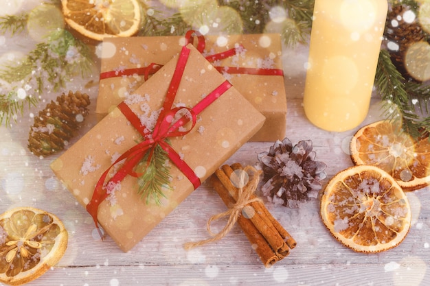 Zdjęcie Świąteczne dekoracje z prezentami, śniegiem, pomarańczą i cynamonem