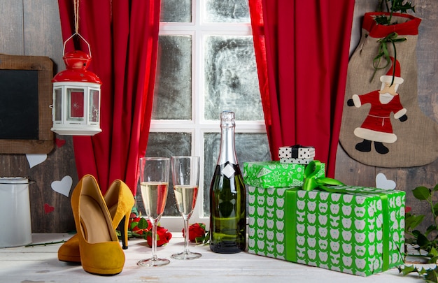 Świąteczne dekoracje z prezentami, szklankami i butelką szampana