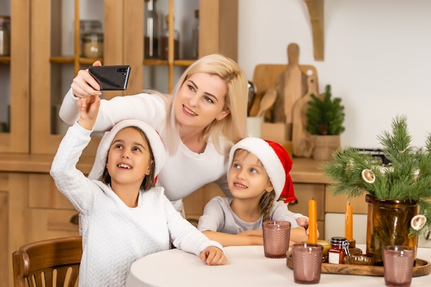 Świąteczne gratulacje rodzinne online. Uśmiechnięta europejska blondynka matka i córka za pomocą mobilnego tabletu do rozmów wideo z przyjaciółmi i rodzicami.