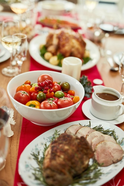 Świąteczne jedzenie pieczona wołowina lub warzywa pomidorowe na stole jadalnym w pustym domu lub restauracji Powiększ teksturę i świąteczną szynkę mięsną lub indyka dziękczynienia na spotkaniu towarzyskim lub obiedzie