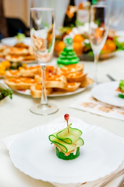 Świąteczne kanapki z łososiem i ogórkiem w formie choinki na rodzinnym świątecznym stole