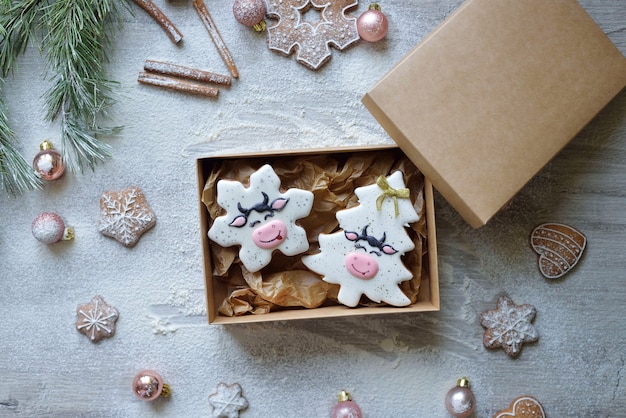 Świąteczne pierniczki w glazurze w formie choinek Symbole bożonarodzeniowe 2021, zapakowane w rzemieślnicze pudełko do dostawy do domu. koncepcja dostawy żywności nowy rok.
