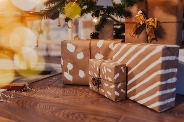 Świąteczne prezenty zawinięte w papier pakowy pod choinką.