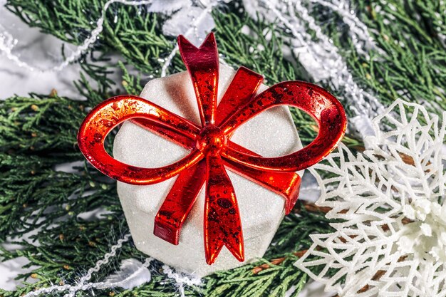 Zdjęcie Świąteczne pudełko i płatek śniegu na gałęzi drzewa iglastego koncepcja bożego narodzenia nowego roku