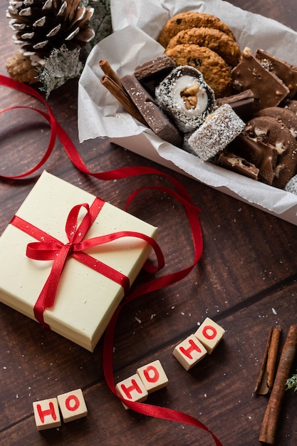 Świąteczne pudełko na prezent i słodycze z dekoracjami pór roku na drewnianym tle