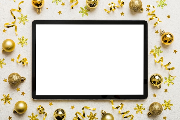 Świąteczne zakupy online z domu Tablet PC z pustym białym wyświetlaczem widok górny Tablet z przestrzenią kopiowania na kolorowym tle z dekoracjami świątecznymi kulkami Tło sprzedaży świąt zimowych