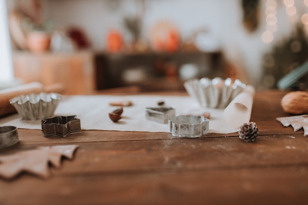 świąteczny drewniany stół kuchenny z narzędziami do gotowania wałkiem do ciastek i foremek do ciastek bez ludzi