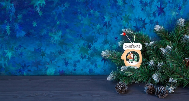 Świąteczny nastrój Kartka świąteczna Gałęzie choinki z szyszkami drewniana zabawka z napisem Boże Narodzenie Atmosfera wakacji Z miejsca na kopię