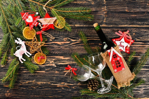 Zdjęcie Świąteczny stół służący i butelka wina nowy rok choinka i ozdoby choinkowe na drewnianym tle wolne miejsce na tekst