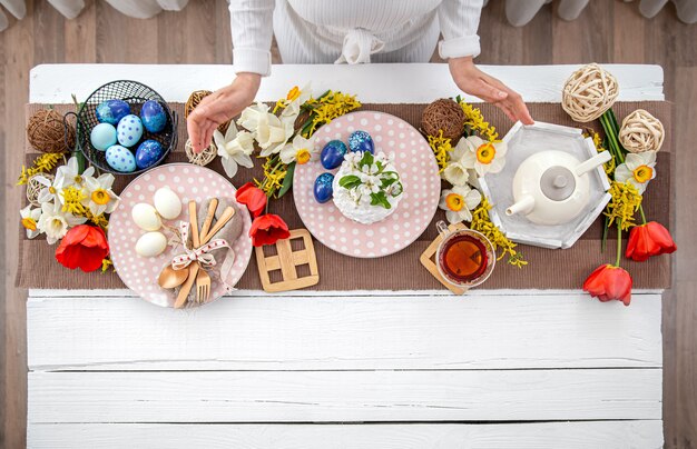 Zdjęcie Świąteczny stół wielkanocny z domowym ciastem wielkanocnym, herbatą, kwiatami i detalami dekoracyjnymi. koncepcja uroczystości rodzinnych.
