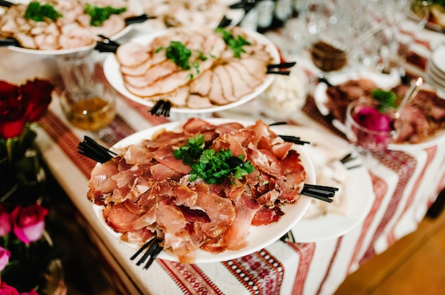 Świąteczny stół z przystawką, przekąski mięsne. Podany stół z jedzeniem. Stolik w restauracji.