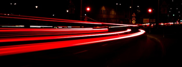 Światła samochodów w nocy Linia ulic autostrada miasto Długa ekspozycja droga Kolorowe pasy czerwonych szlaków