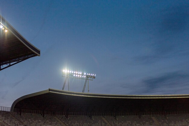 Światła stadionu świecące na niebieskim niebie podczas niebieskiej godziny