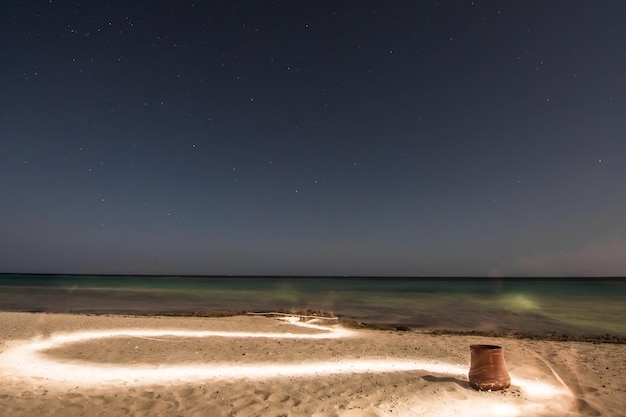 Światły szlak na plaży z jasną gwiazdistą nocą na wakacjach