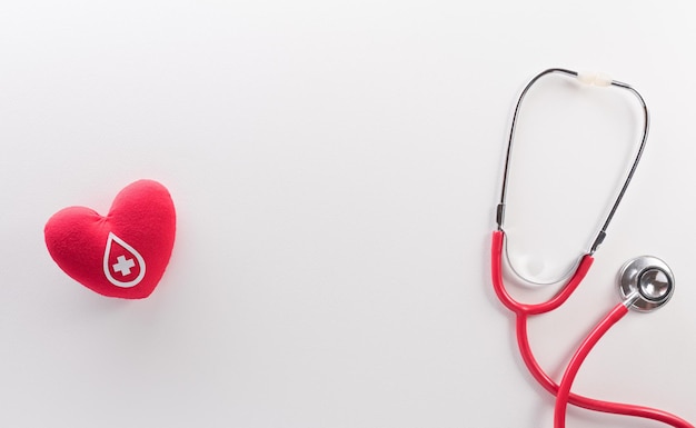 Światowy dzień dawcy krwi czerwony krzyż i koncepcja dnia pielęgniarki z czerwonego serca i stetoskopu na białym tle