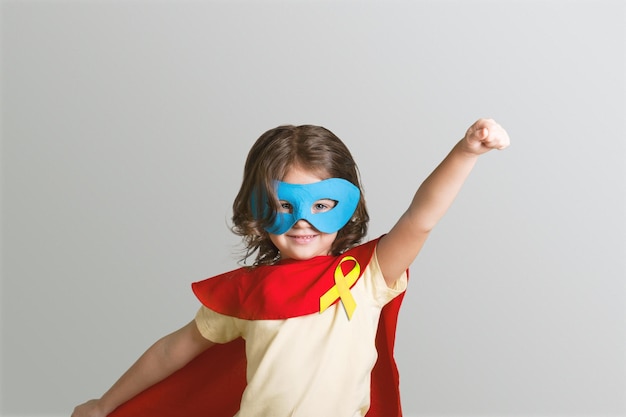 Światowy Dzień Nowotworów Dziecięcych. Dziewczyna w kostiumie superbohatera pozowanie
