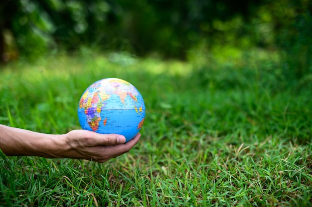 Światowy Dzień Ochrony Środowiska .Kochaj świat .Ręka trzymająca globus