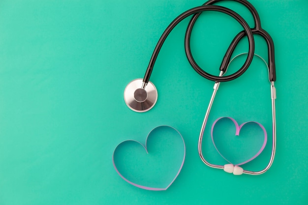 Światowy zdrowie dnia tło, stetoskop i różowy tasiemkowy serce na zielonym tle, pojęcie opieka zdrowotna i medyczny tło
