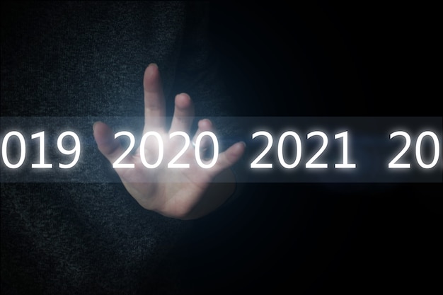 Świecące numery roku 2020 i sieć nad ręką na czarnym tle. Nowa technologia 2020 roku