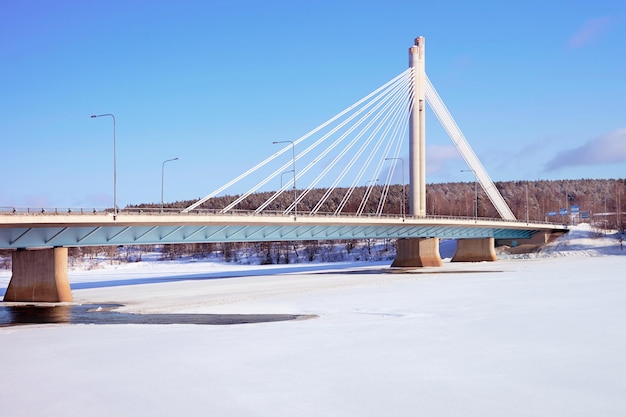 Świecowy most z błękitnym niebem w pokrytym śniegiem Rovaniemi, Laponia, Finlandia