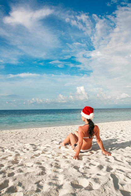 Święta Bożego Narodzenia - kobieta w santa hat na plaży