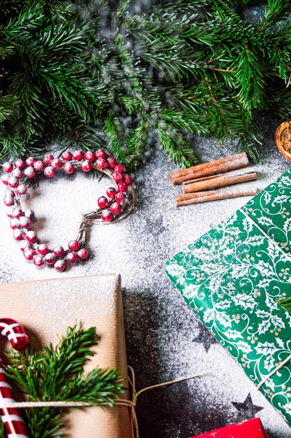 Zdjęcie Święta bożego narodzenia opakowanie prezentów zdjęcie ze śniegiem nowy rok pudełka z kraft czerwony zielony papier dekoracja cynamon suche pomarańcze