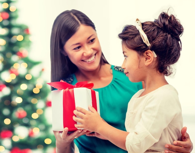 święta, prezenty, boże narodzenie, koncepcja bożonarodzeniowa - szczęśliwa mama i dziecko dziewczynka z pudełkiem na prezent