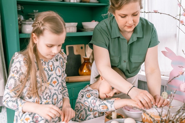 Zdjęcie Święta wielkanocne w sezonie wiosennym szczęśliwa rodzina szczere małe dzieci siostry dziewczyny razem matka bawi się w domu dekorowanie stołu na lunch lub kolację tradycyjne jedzenie świąteczny wystrój domu